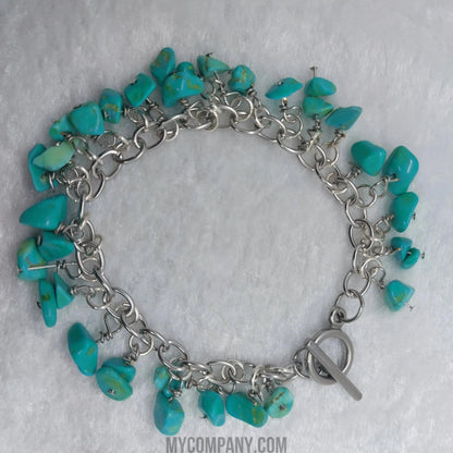 Silver stainless steel charm bracelet with numerous turquoise howlite gemstone chips.