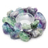 A circular arrangement of colorful fluorite crystals in shades of green and purple surrounds a clear glass dish. The crystals are rough and unpolished, showcasing their natural beauty.