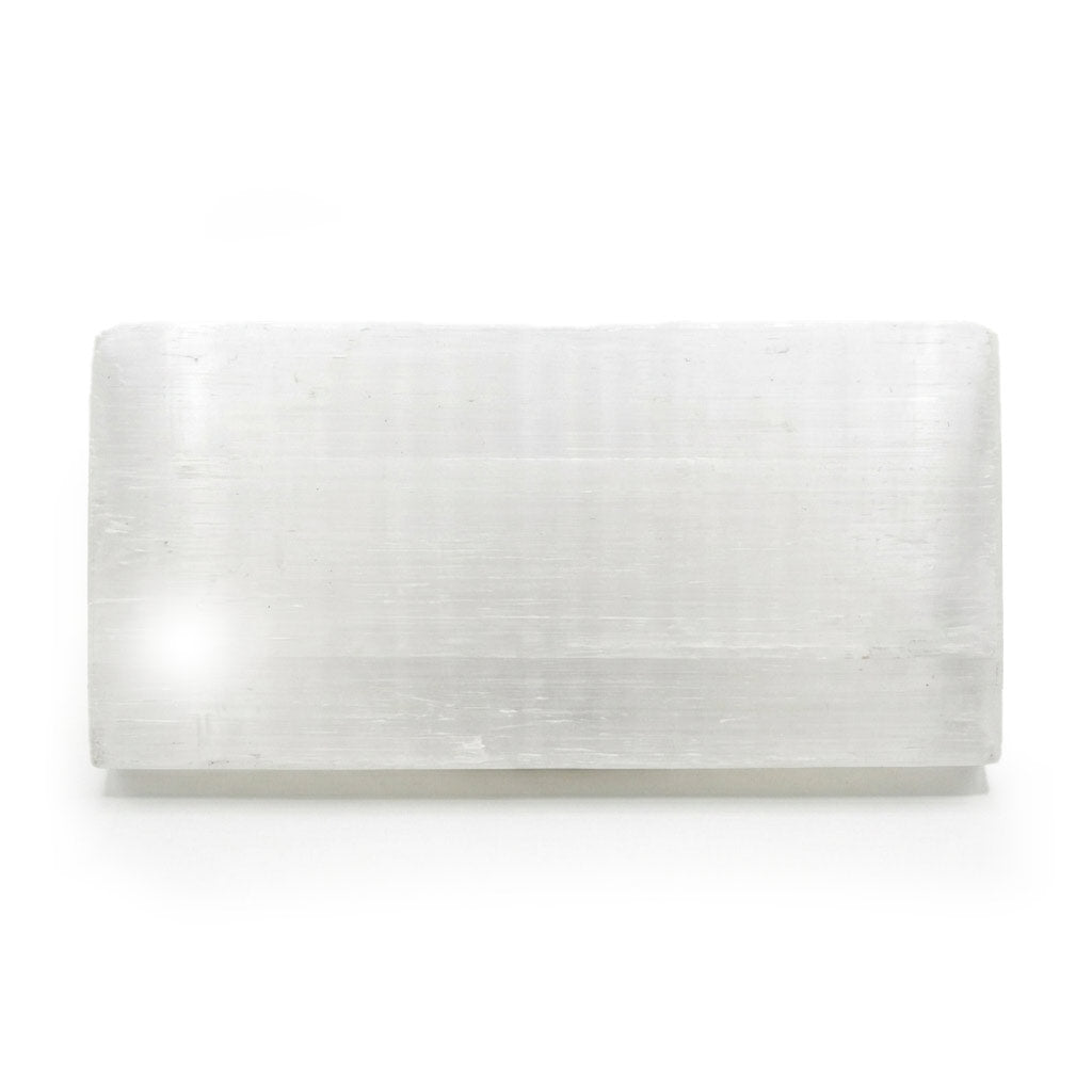 Flat polished white selenite charging plaque measuring 4 by 8 inches, showing smooth satin spar surface with fine fibrous streaks on a neutral background