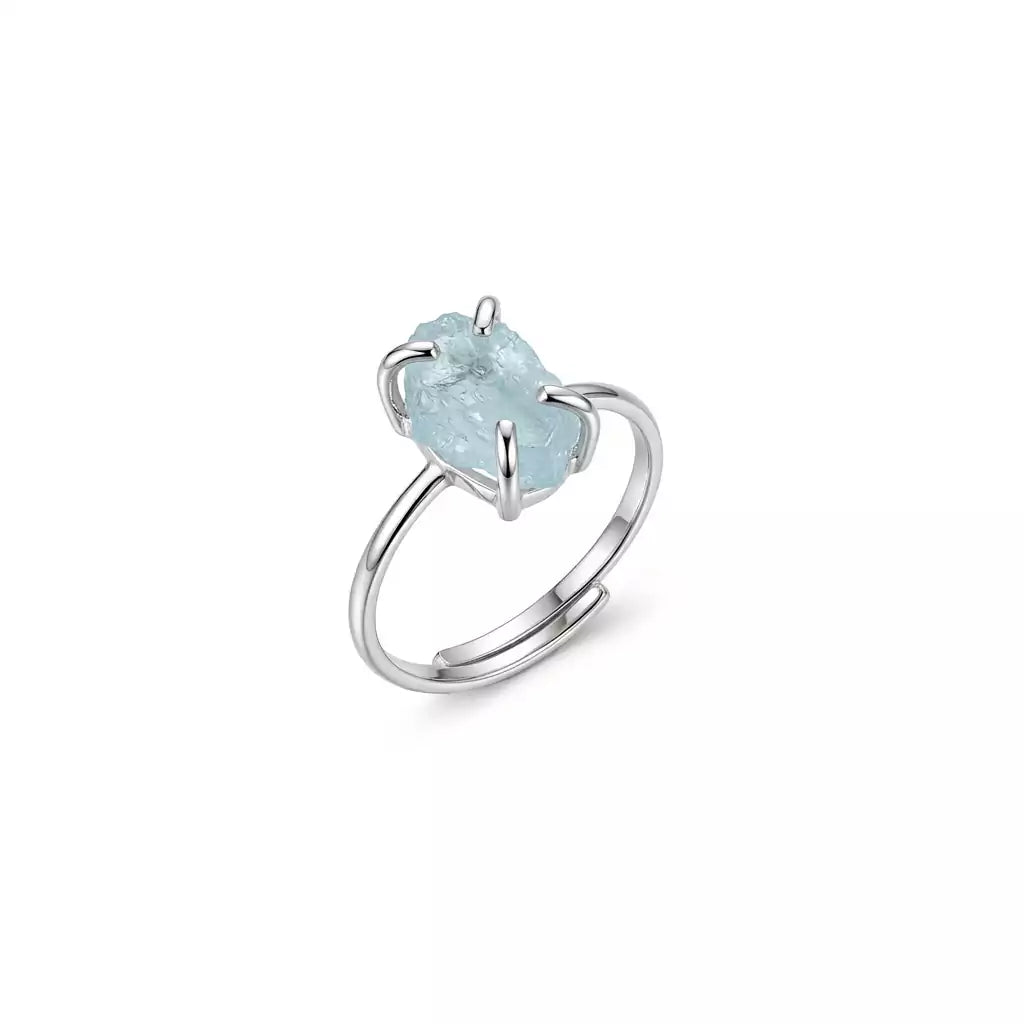 Aquamarine adjustable crystal ring with a soft blue stone set on an open silver-toned band displayed on a white background