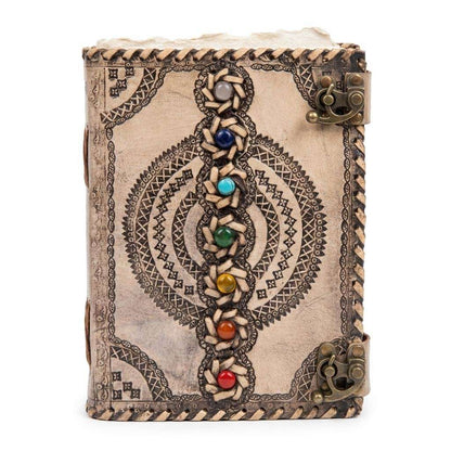 Decorative leather-bound journal with chakra gemstone inlays and intricate tooled patterns on the cover — dual metal clasp closure.