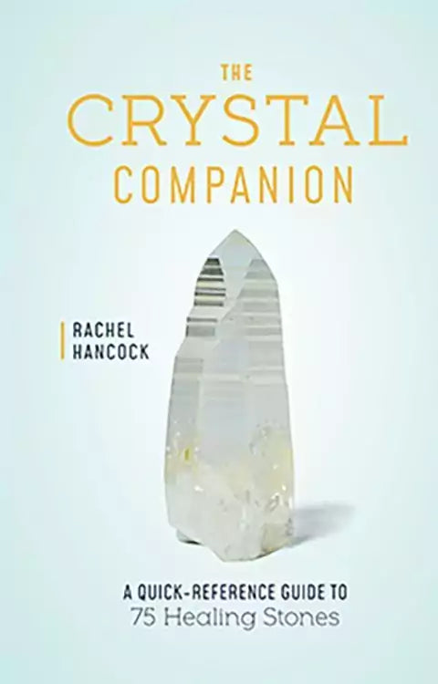 Clear quartz crystal standing upright against a light blue background beside the title The Crystal Companion Quick-Reference Guide to 75 Healing Stones