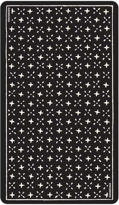 Dark surface showing the back design of the Glow in the Dark Tarot cards — a repeating pattern of small white stars on black.