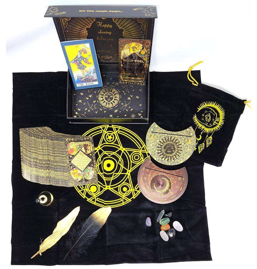 Mystical Rider-Waite gold foil tarot set displayed on black cloth with cards, crystals, and ritual tools with celestial and alchemical symbols.