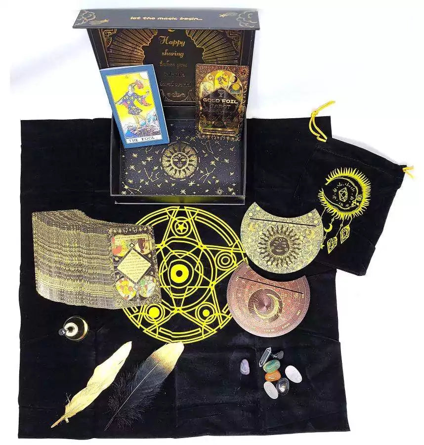 Mystical Rider-Waite gold foil tarot set displayed on black cloth with cards, crystals, and ritual tools with celestial and alchemical symbols.