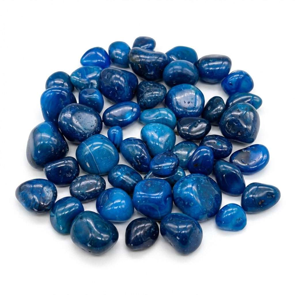 Blue onyx tumbled stones in a pile showing smooth polished surfaces with deep teal coloring — heat-treated chalcedony bulk crystals.