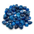 Blue onyx tumbled stones in a pile showing smooth polished surfaces with deep teal coloring — heat-treated chalcedony bulk crystals.