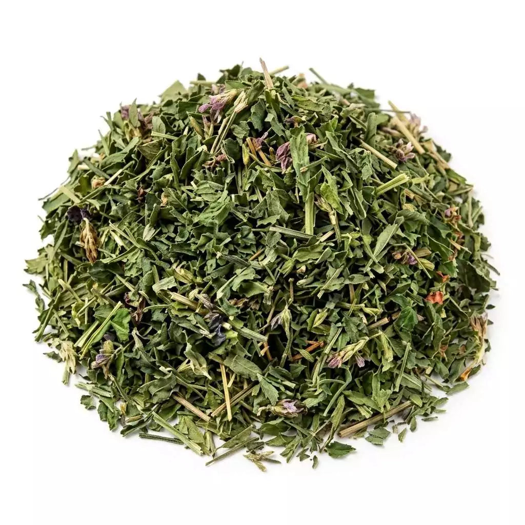 Dried herbs piled in a mound, showcasing a mix of green leaves and stems.