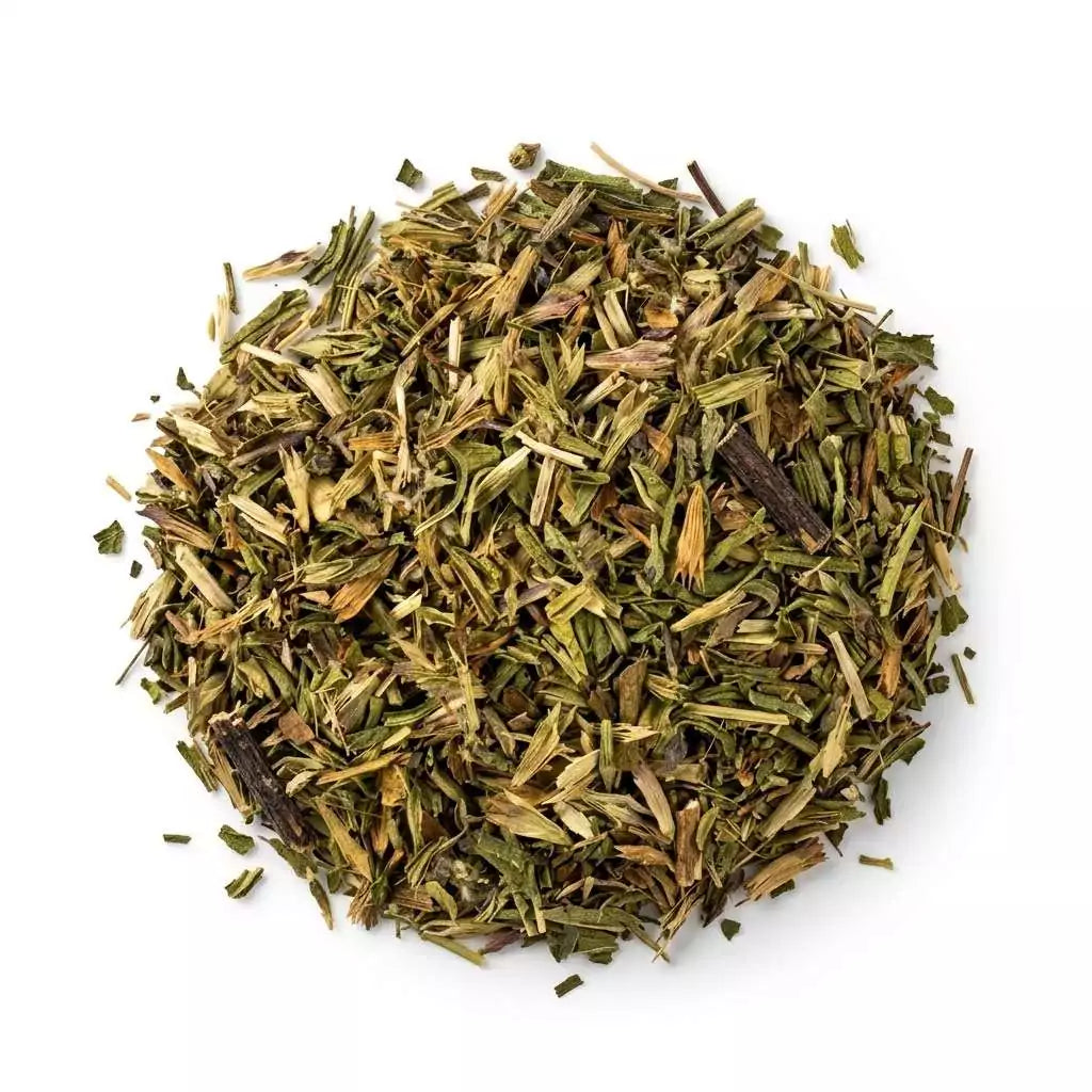 Dried hyssop Hyssopus officinalis cut herb showing finely chopped green and brown plant material mixed in a pile on white background