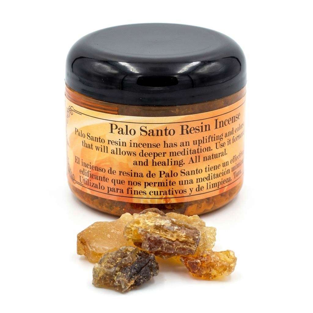 A container of Palo Santo resin incense with pieces of resin scattered around it, used for meditation and healing.