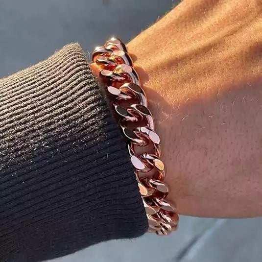 Hand wearing a solid copper heavy link chain bracelet — showing the bold interlocking copper chain design in wear context.