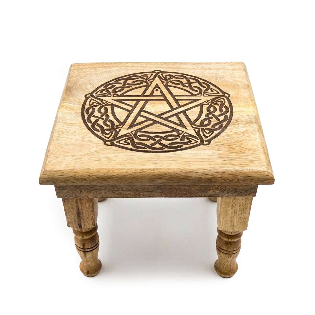 Carved wooden pentagram altar table with intricately cut five-pointed star design and raised leg platform for ritual display