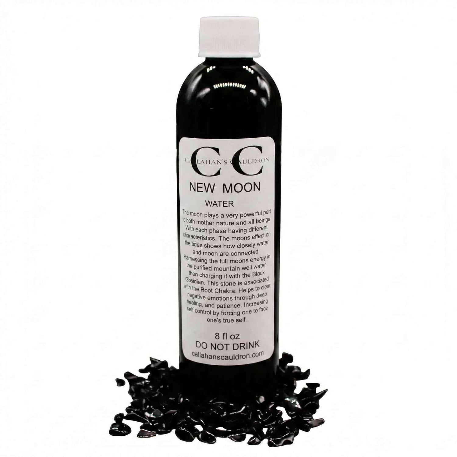 A bottle labeled "New Moon Water" surrounded by small black stones, indicating it is a product for spiritual or ritual use.