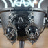 Antique silver bat dangle earrings with black oval cabochons, hanging from a black cauldron.