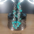 Silver stainless steel bracelet with dangling turquoise howlite gemstone chips.
