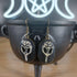 Antique bronze raven skull dangle earrings with black oval settings, hanging from a black cauldron.