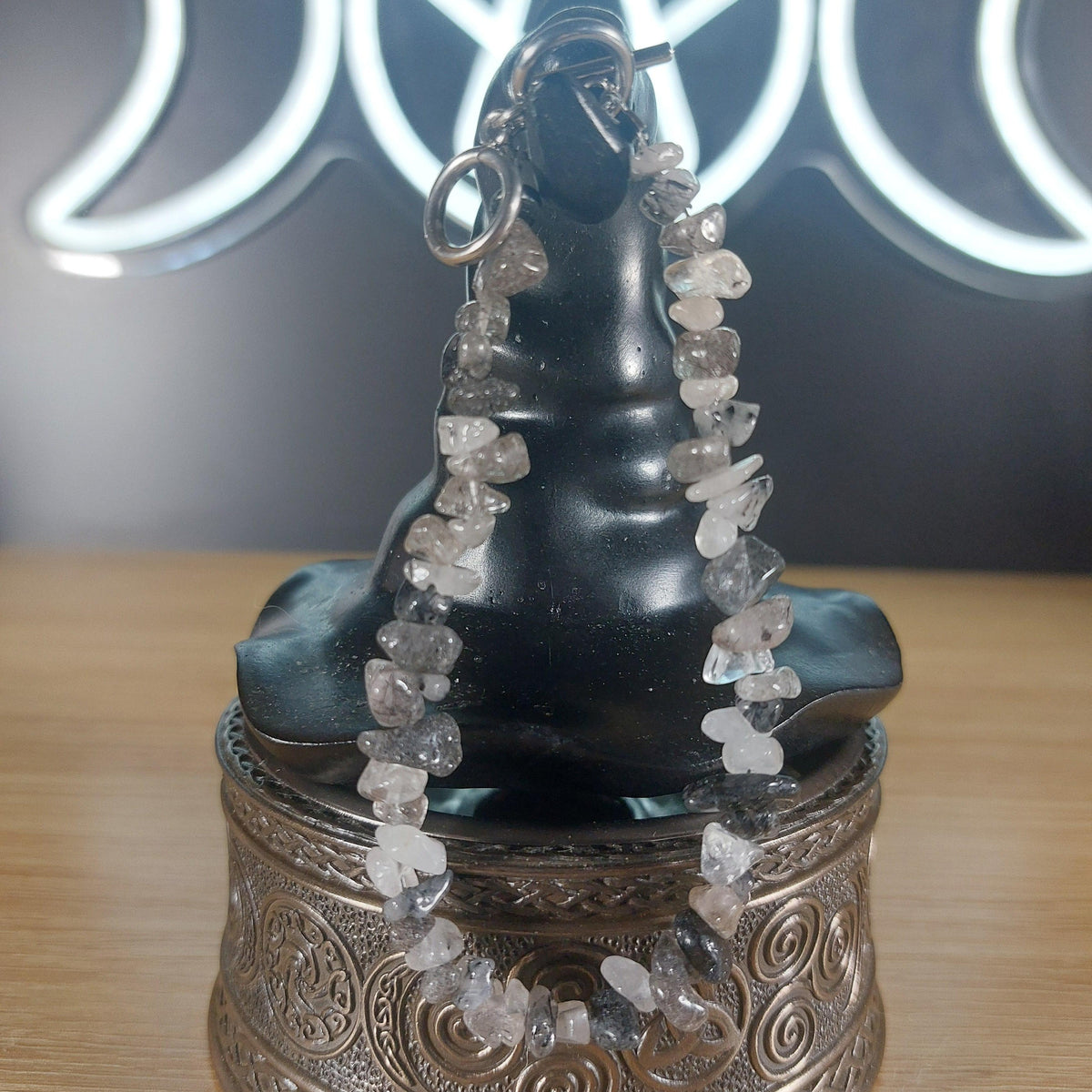 Smoky Quartz crystal chip bracelet with stainless steel toggle clasp, displayed on a black witch hat stand.
