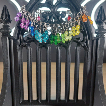 Rainbow bicone beaded bracelet with stainless steel chain, displayed on a black gothic stand.